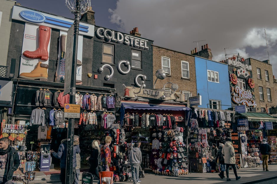 The image shows the exterior of Camden Quality Fish, a fish and seafood shop located at street level in a brick building, with a predominantly blue sign displaying the business name and related text. 